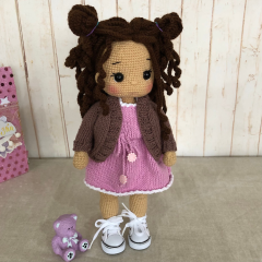 Gehäkelte Flechtpuppe mit braunem Haar, rosa Kleid und Jacke