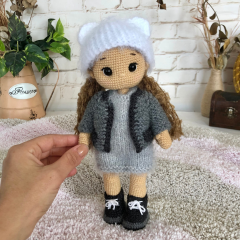 Muñeca de ganchillo personalizada con pelo castaño rizado y ropa gris y simpático conejo de juguete