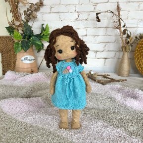 Treffen Sie die geflochtene Häkelpuppe mit braunem Haar und blauem Kleid mit Eiscreme-Aufdruck