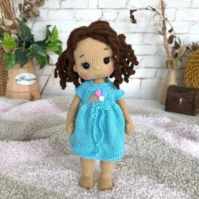 Treffen Sie die geflochtene Häkelpuppe mit braunem Haar und blauem Kleid mit Eiscreme-Aufdruck