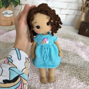 Treffen Sie die geflochtene Häkelpuppe mit braunem Haar und blauem Kleid mit Eiscreme-Aufdruck
