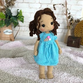 Treffen Sie die geflochtene Häkelpuppe mit braunem Haar und blauem Kleid mit Eiscreme-Aufdruck