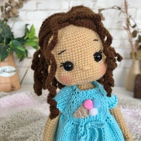 Treffen Sie die geflochtene Häkelpuppe mit braunem Haar und blauem Kleid mit Eiscreme-Aufdruck