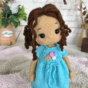 Treffen Sie die geflochtene Häkelpuppe mit braunem Haar und blauem Kleid mit Eiscreme-Aufdruck
